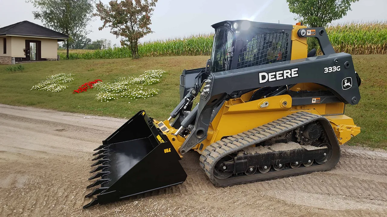 A compact track loader moving soil on a landscape job site — landscaping insurance in Washington.